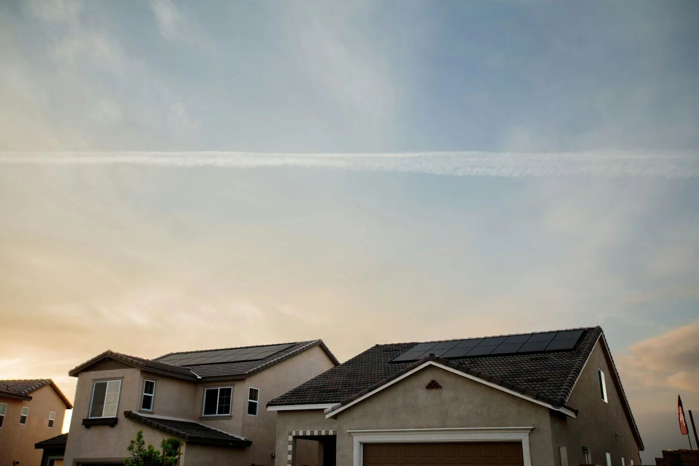 Homes with rooftop solar panels at sunset